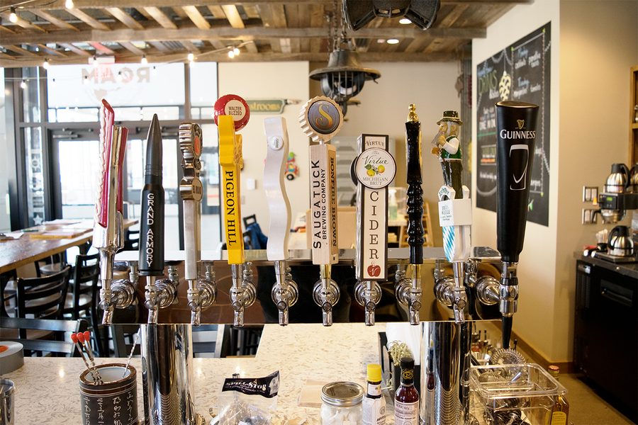 The ROAM bar: a row of tap handles from Michigan breweries in front of a chalkboard drinks list.